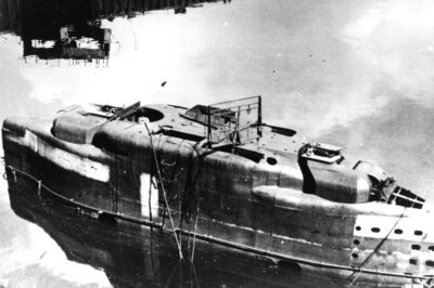 The bridge of U-3045, seen here post-war, reveals the advanced features of Germany’s Type XXI U-boat…the world’s first true submarine rather than a diving torpedo boat. Even in scuttled form, the enclosed conning tower stands out, fitted with a retractable radar antenna and twin machine gun turrets for anti-aircraft defence.  Sleek and hydrodynamic, these boats were designed for extended submerged operations, capable of running silently underwater for days…a revolutionary leap in submarine warfare.