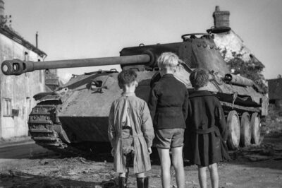 Unbelievable Moment in History! French Boys Stare in Awe at a Destroyed German Panther Tank in the Heart of the Falaise Pocket, Normandy, August 25, 1944—The Silent Witness to a Brutal Battle, But What Did This Iconic Scene Reveal About the Turning Point of WWII and the Fate of the German War Machine?