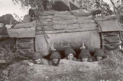 This M10 tank destroyer crew from the 703rd Tank Destroyer Battalion takes cover in a hole under their vehicle, in Normandy, France 1944.