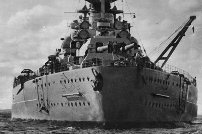 A stern view of the German battleship Bismarck, taken sometime between 1940 and 1941. The photo highlights her massive hull and twin rudders, which gave the ship good maneuverability for her size. She was the largest warship ever built by Germany.