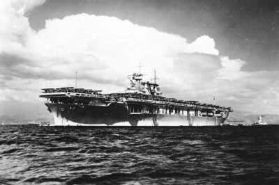 The U.S. Navy aircraft carrier USS Yorktown (CV-5) anchored in Haitian waters, circa 1938-1940. Note the Curtiss SOC Seagull taxiing off Yortown’s bow and the New Mexico-class battleship in the background.
