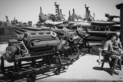 PT-208, a Higgins 78-foot motor torpedo boat in zebra paint, receiving three new Packard W-14 M2500 replacement engines at Bizerte, Tunisia, 1943.