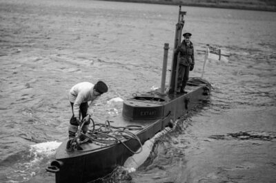 Standing by the conning tower of the midget submarine HMS EXTANT at Holy Loch is the Commander, Lieutenant J G Clarke, RNR.