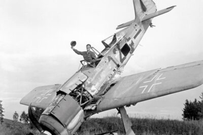 A GI is seen waving from the cockpit of a downed German Focke-Wulf Fw 190 fighter, Pocking, Bavaria, Germany, World War II, July 1945.