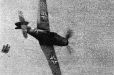 A Supermarine Spitfire flown by Warrant Officer B Bunting of No. 93 Squadron RAF fires at a Bf-109G as the pilot attempts to bail out.